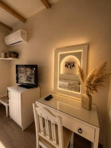 a room with a white desk and a television at La Hacienda Ras Sedr in Ras Matarma