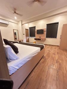 a bedroom with a bed and a flat screen tv at Hotel Param INN in Gwalior