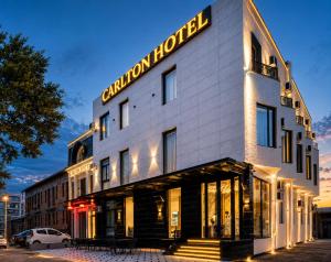 a building with a sign on the side of it at Carlton Hotel Tashkent in Tashkent