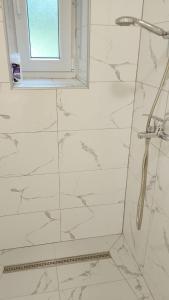 a bathroom with a shower with white marble tiles at JAJCE Historic House in Jajce