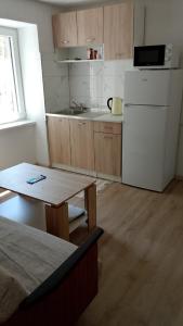 a small kitchen with a white refrigerator and a table at JAJCE Historic House in Jajce