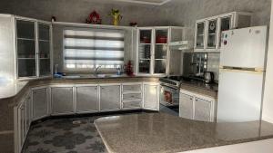 a kitchen with white cabinets and a white refrigerator at Mountain View House- بيت إطلالة الجبل in Ajloun