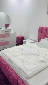 an unmade bed in a bedroom with a dresser at Mountain View House- بيت إطلالة الجبل in Ajloun
