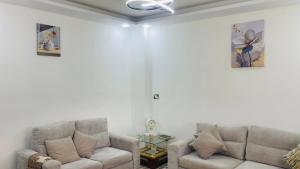 a living room with two couches and a ceiling fan at Mountain View House- بيت إطلالة الجبل in Ajloun +17 photos