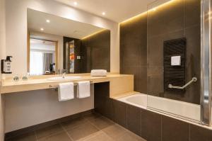 a bathroom with a tub and a sink and a mirror at VM Princep in Andorra la Vella