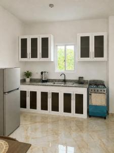 a kitchen with white cabinets and a refrigerator at Alojamiento en Miches in Miches