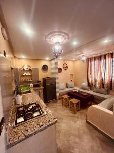 a kitchen and living room with a stove and a couch at Zakar Apartments & Terrace in Mirleft