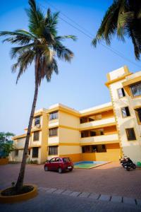 a red car parked in front of a building with a palm tree at Serenity Casa ll in Varca