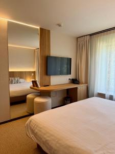 ein Hotelzimmer mit Bett und Schreibtisch mit Fernseher in der Unterkunft Hotel Sirius in Huy + 27 Fotos