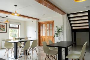 a dining room with black tables and white chairs at Centro Turistico Lafquintue in Ranco