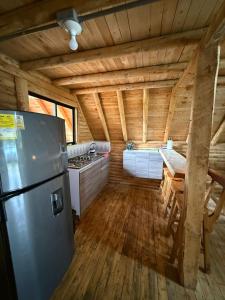 a kitchen in a log cabin with a refrigerator at Chalet Amar in Mazo