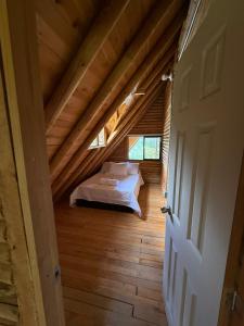 a bedroom with a bed in a wooden attic at Chalet Amar in Mazo