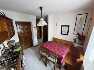 a kitchen with a table with a red blanket on it at Casa Adry in Cles +7 photos
