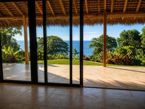 an open room with a view of the ocean at ITAMPOLO Suites & Lodges in Nosy Be