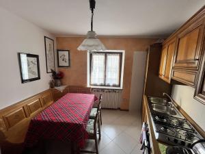 a kitchen with a table with a red tablecloth on it at Casa Adry in Cles