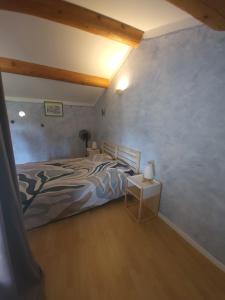 a bedroom with a large bed and a wooden floor at Au 3 bis in Caderousse +7 photos