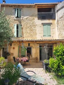 a stone house with a table and a patio at Au 3 bis in Caderousse