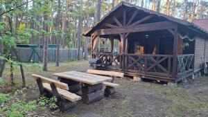 a wooden hut with a picnic table and a bench at Domek w Turawie in Turawa