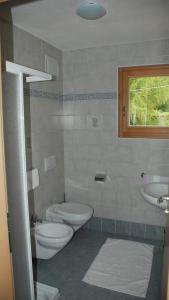 サン・マルティーノ・イン・バディーアにあるCiasa Elkeのバスルーム(トイレ、洗面台付)、窓が備わります。