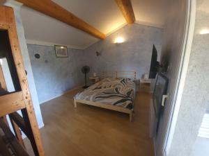 a bedroom with a bed and a wooden floor at Au 3 bis in Caderousse