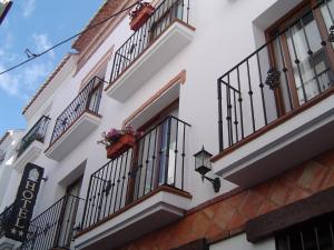 a white building with balconies and a street sign at Hotel Alandalus in Torrox