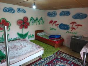 a bedroom with a bed and a wall covered in graffiti at Mary's Home in Korumdy