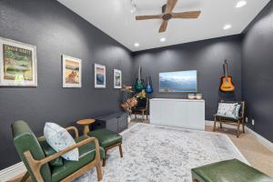 a living room with a ceiling fan and guitars on the wall at Flatlanders Retreat in Twain Harte