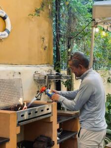 a man is cooking over a fire in a grill at Outdo'r Garden House in Tuy Hoa +7 photos
