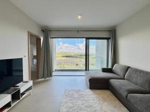 a living room with a couch and a large window at Haven Suites in Moka