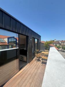 a wooden deck with chairs on top of a building at APARTAMENTOS LLAMIEVA in Posada de Llanes