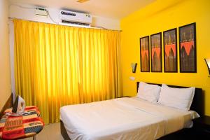 a yellow bedroom with a bed and a yellow curtain at Serenity Casa ll in Varca