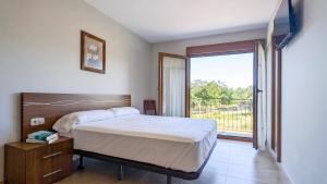a bedroom with a bed and a large window at Duerming La Rana Sanxenxo in Sanxenxo +15 photos