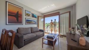 two people standing in a living room with a couch at Duerming La Rana Sanxenxo in Sanxenxo