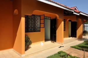 a house with orange walls and a courtyard at Majimbo Whitehouse Resort in Ramogi