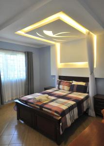 a bedroom with a large bed with a large ceiling at Majimbo Whitehouse Resort in Ramogi +1 photo