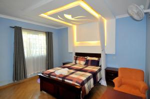 a bedroom with a bed and an orange chair at Majimbo Whitehouse Resort in Ramogi