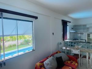 a living room with a couch and a table and a window at Hostel Meu Sossego Vilas in Lauro de Freitas