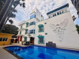 a house with a swimming pool in front of a building at LuXus Resort & Swimming Pool in Pondicherry