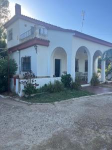 a white house with a balcony on the side at Chalet con piscina en Carmona in Carmona +29 photos