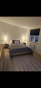 a bedroom with a bed and a window and two lamps at NordNest in Frederiksværk
