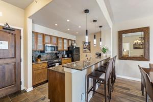 a kitchen with a large island with bar stools at Walk to Beaver Creek Village - 2BR Condo with Chairlift Views, Pool & Hot Tub in Beaver Creek