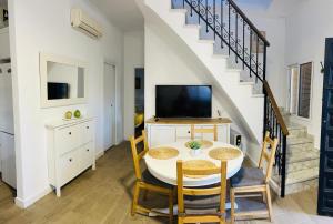 a dining room with a table and a tv at Chalet con piscina en Carmona in Carmona