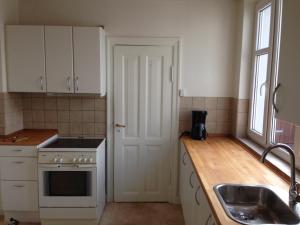 a kitchen with white cabinets and a sink at Klarskov Bed & Breakfast in Klarskov