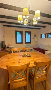 a dining room with a wooden table and chairs at El Boj in Canfranc