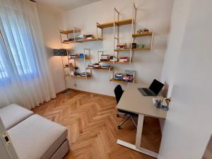 a room with a desk and a bed and a desk with a laptop at Modern Apartment Empoli in Empoli +19 photos
