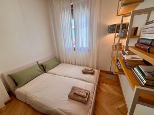 a small room with a bed with two towels on it at Modern Apartment Empoli in Empoli