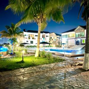 a resort with a swimming pool and palm trees at Lois Beach Resort in Nyanyanu