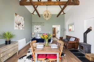 a living room with a table and a couch at Beautiful Cotswold Couples Retreat in Bourton on the Water
