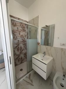 a bathroom with a sink and a shower at Alexandra Rooms & Suitess in Sassari