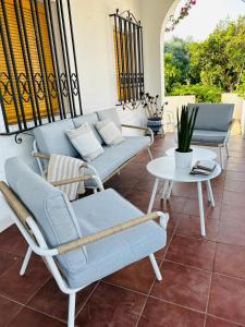 a patio with a couch and chairs and a table at Chalet con piscina en Carmona in Carmona